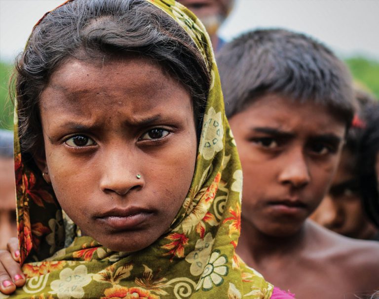 Bangladeshi girl with head covering with other children behind her