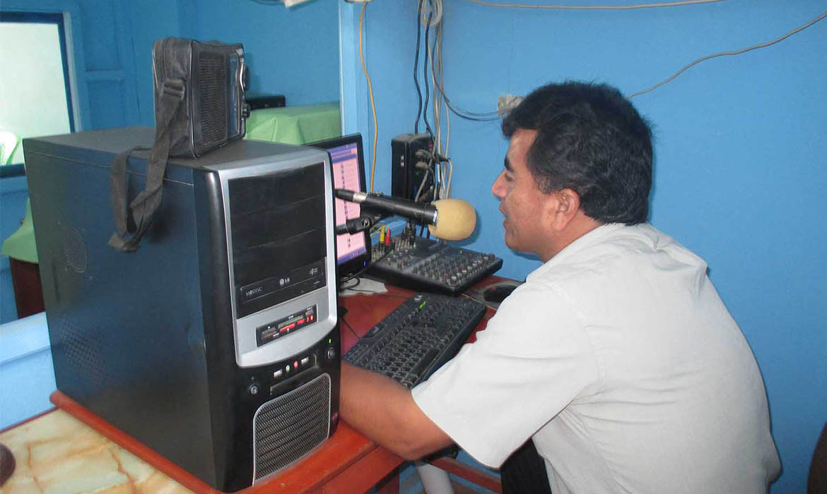 Middle Eastern Christian man speaking into a microphone during a radio broadcast