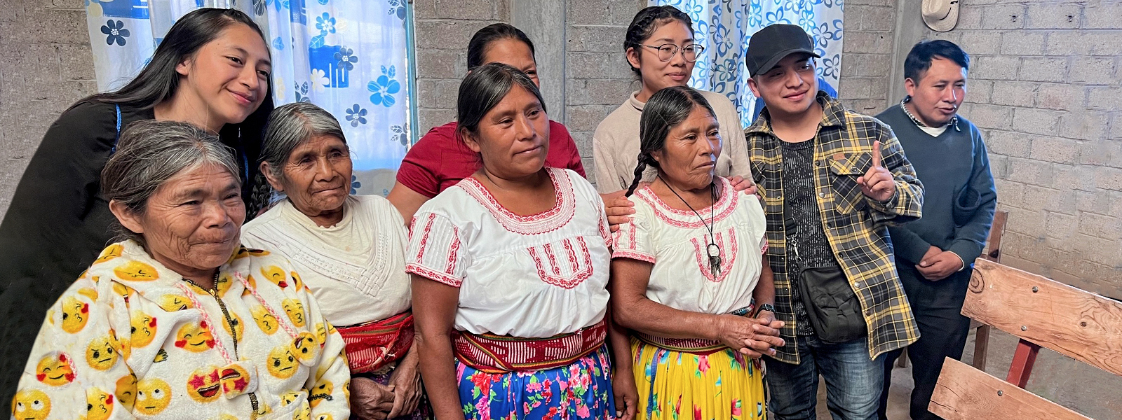 Christians in Mexico gather for a picture in their church building made from gray bricks