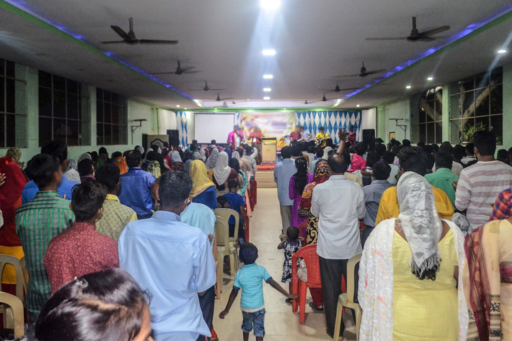 Christians in South Asia gathered together in a green room singing praises to God