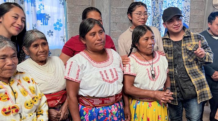 Christians in Mexico gather for a picture in their church building made from gray bricks
